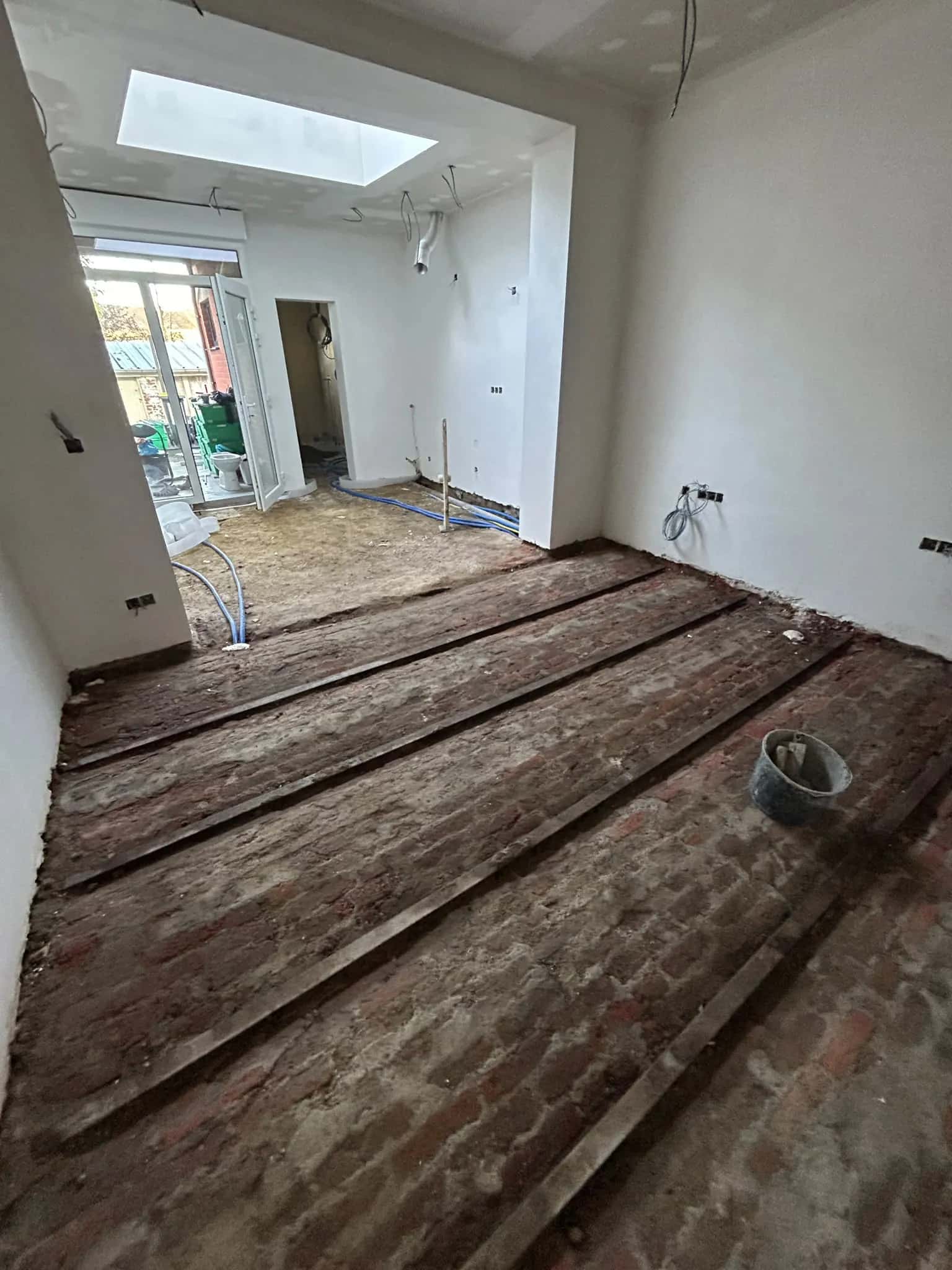 Règles de guidage alignées sur l'ancien sol en briques avant le coulage