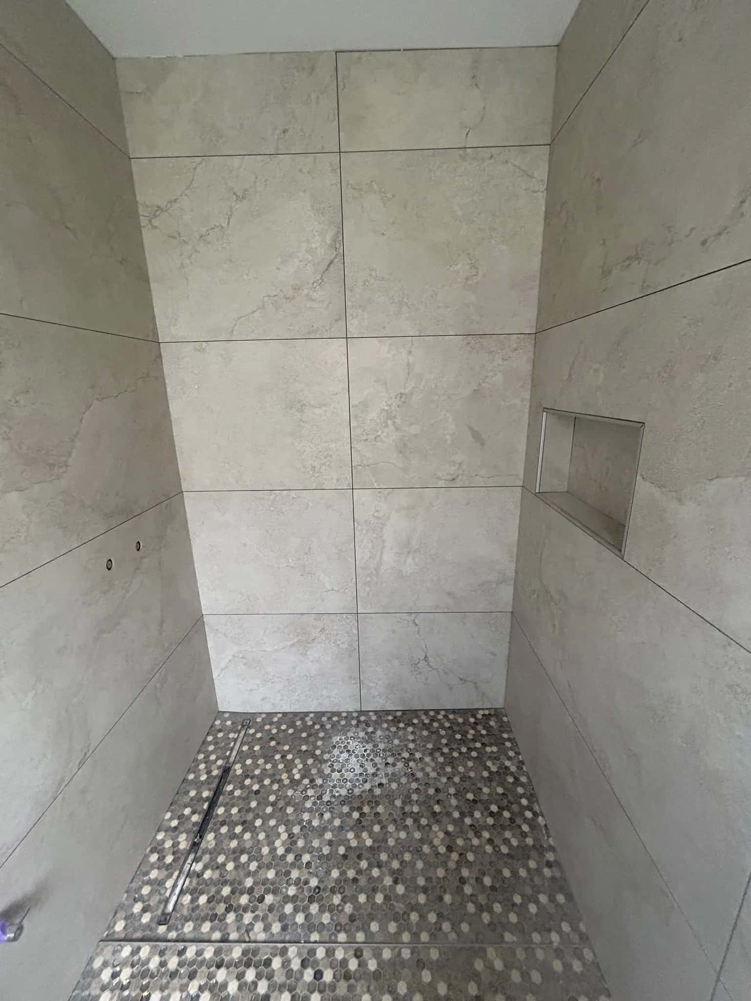 Douche à l'italienne, niche murale et sol en mosaïque hexagonale