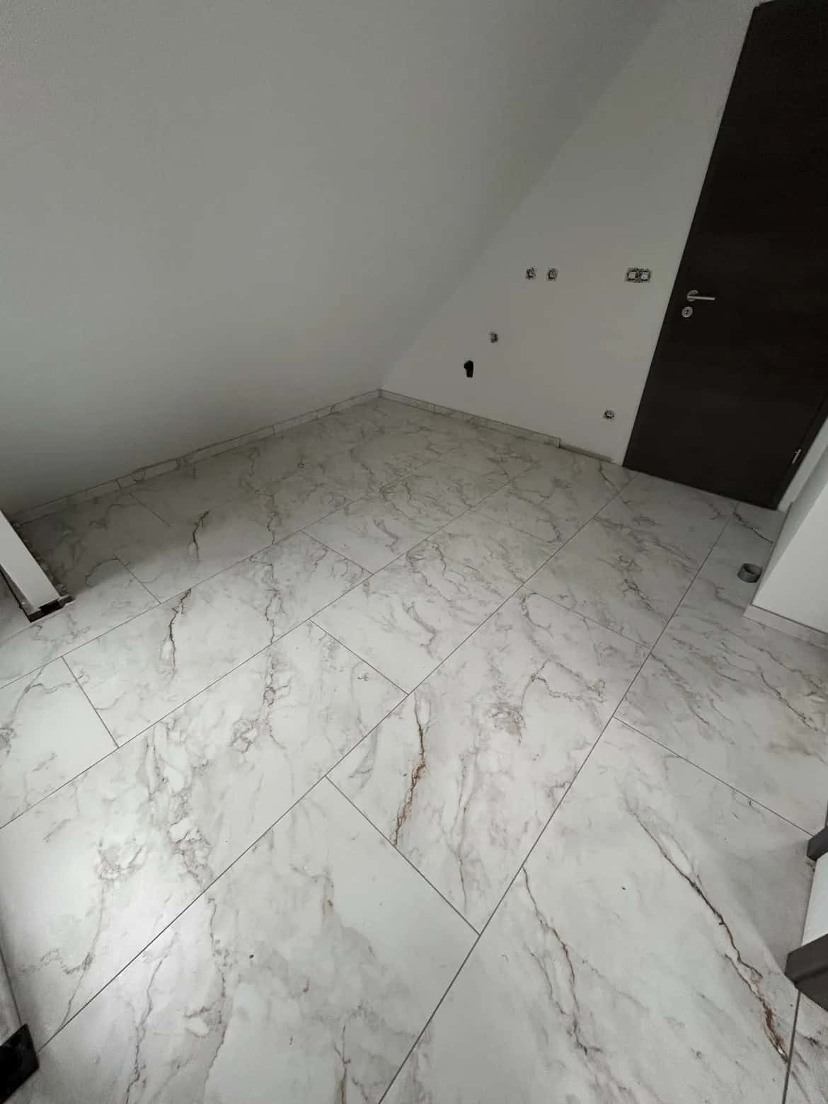 Angle de chambre sous la pente de toit, grands formats posés jusqu'aux murs