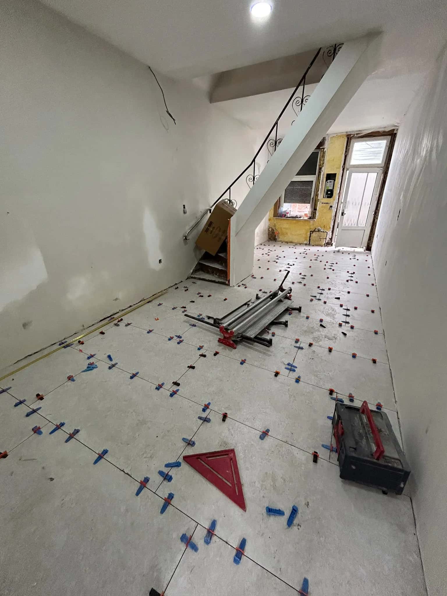 Carreaux tenus par les niveleurs, coupe-carreau et outillage sur le chantier