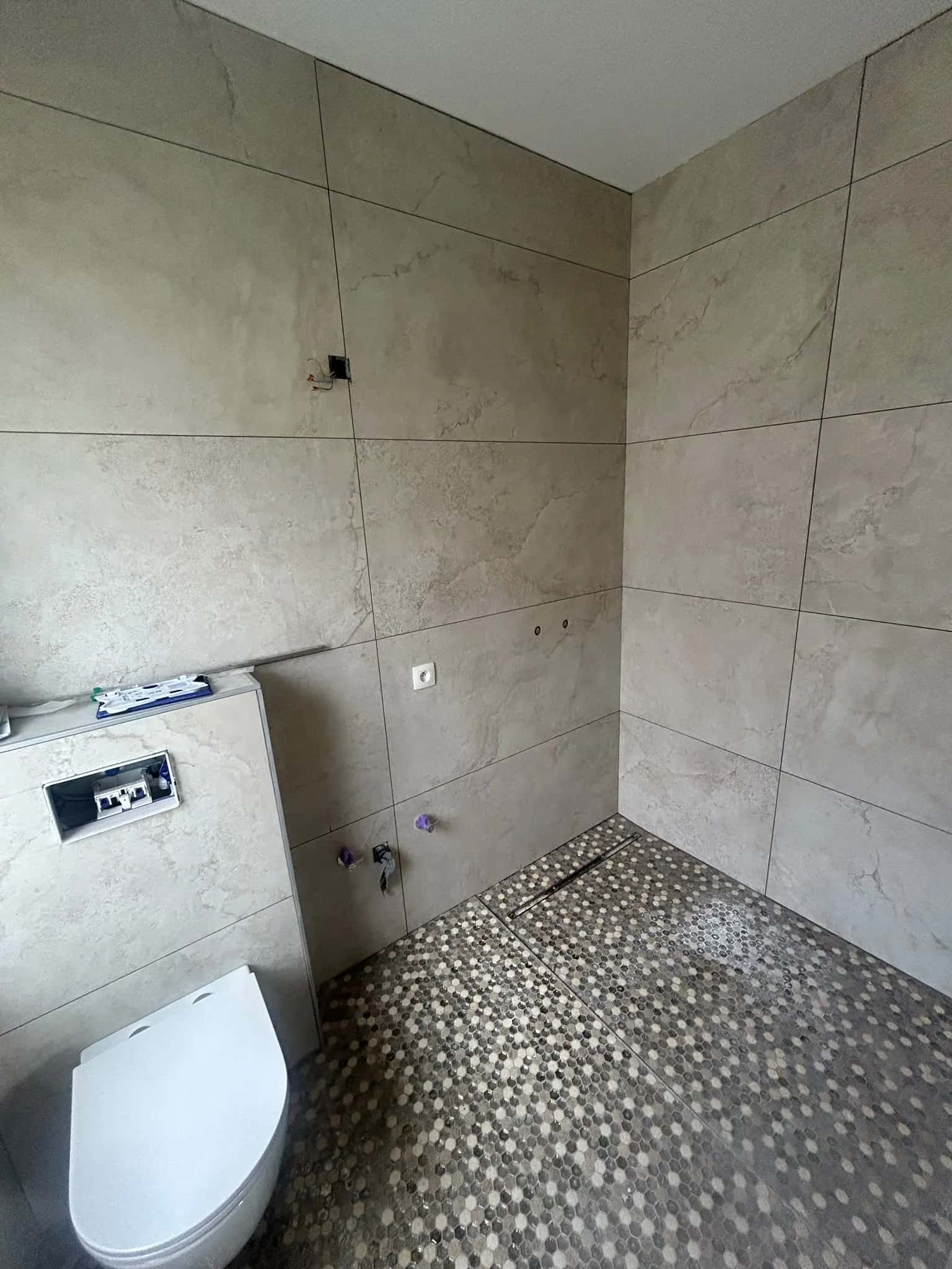 Salle de bain vue depuis la porte, douche à l'italienne au fond