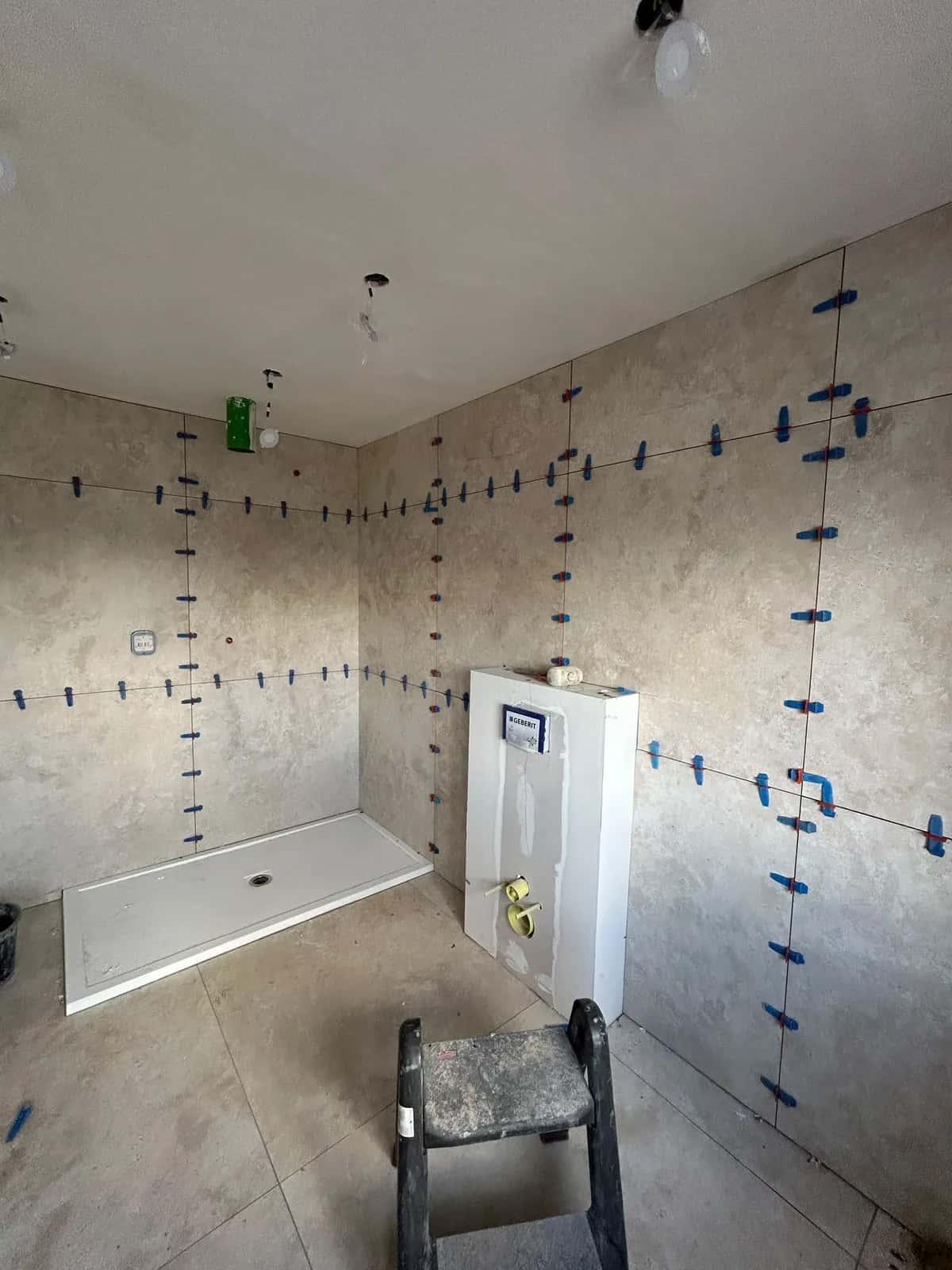 Mur carrelé autour du bâti-support, niveleurs encore en place