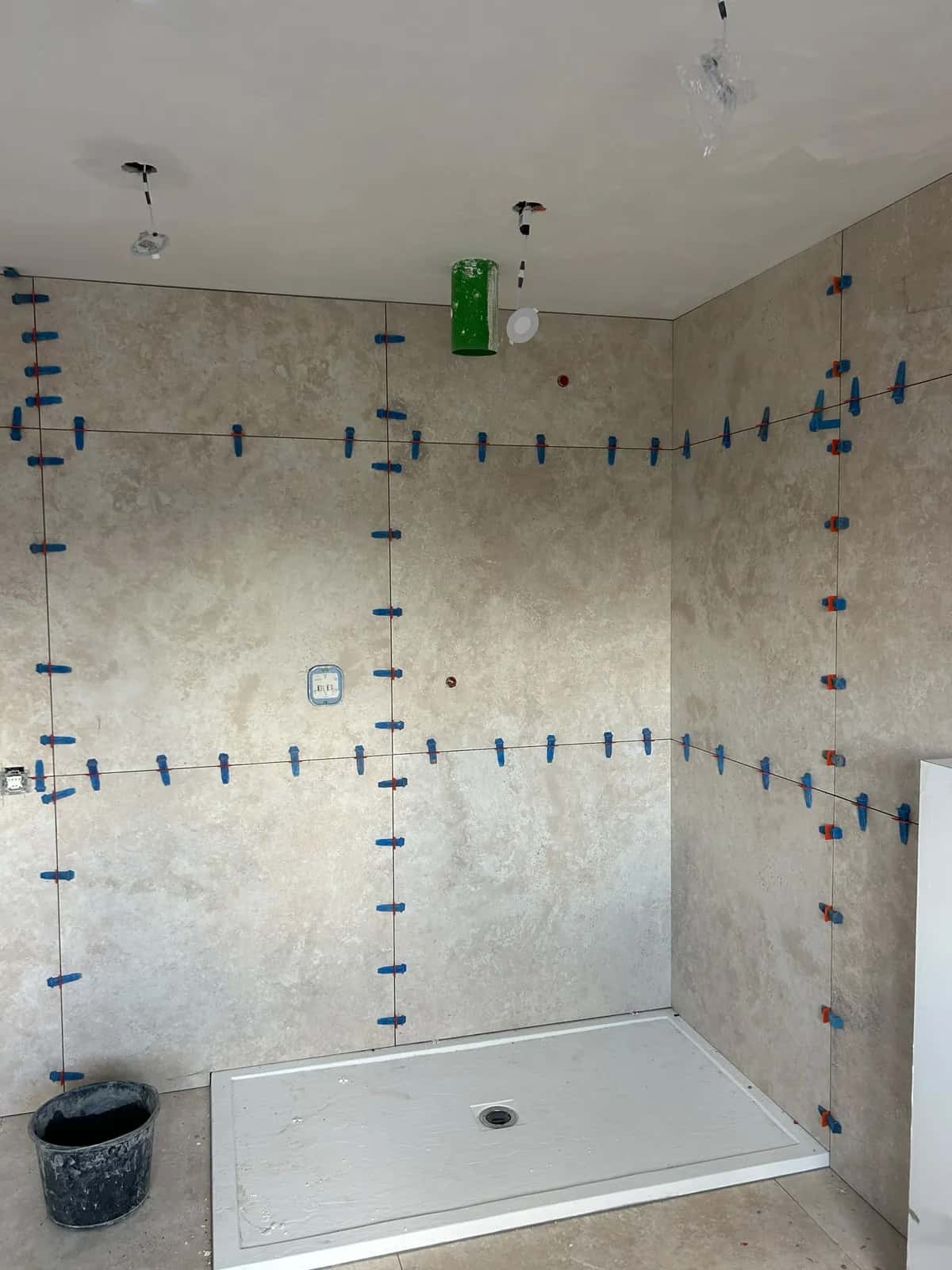 Angle de douche en grand format, niveleurs sur chaque joint avant séchage
