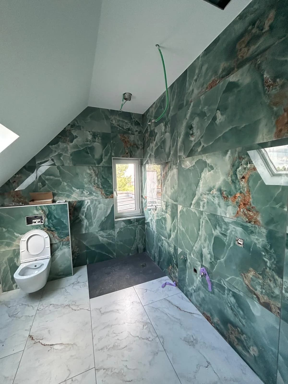 Salle de bain en marbre vert avec douche à l'italienne, posée par Km pose
