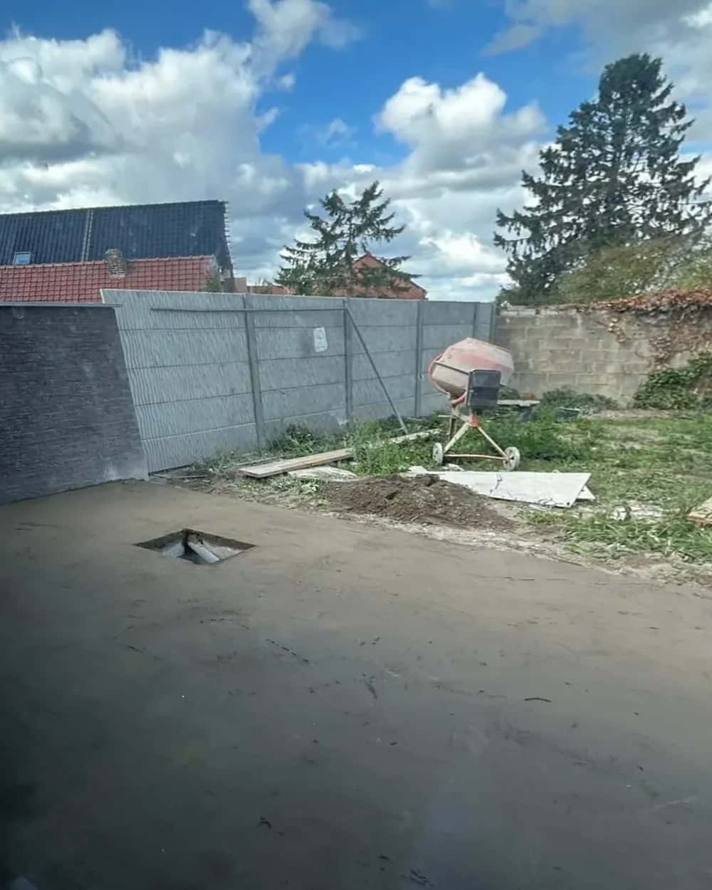 Chape béton fraîchement coulée, regard d'évacuation encore ouvert