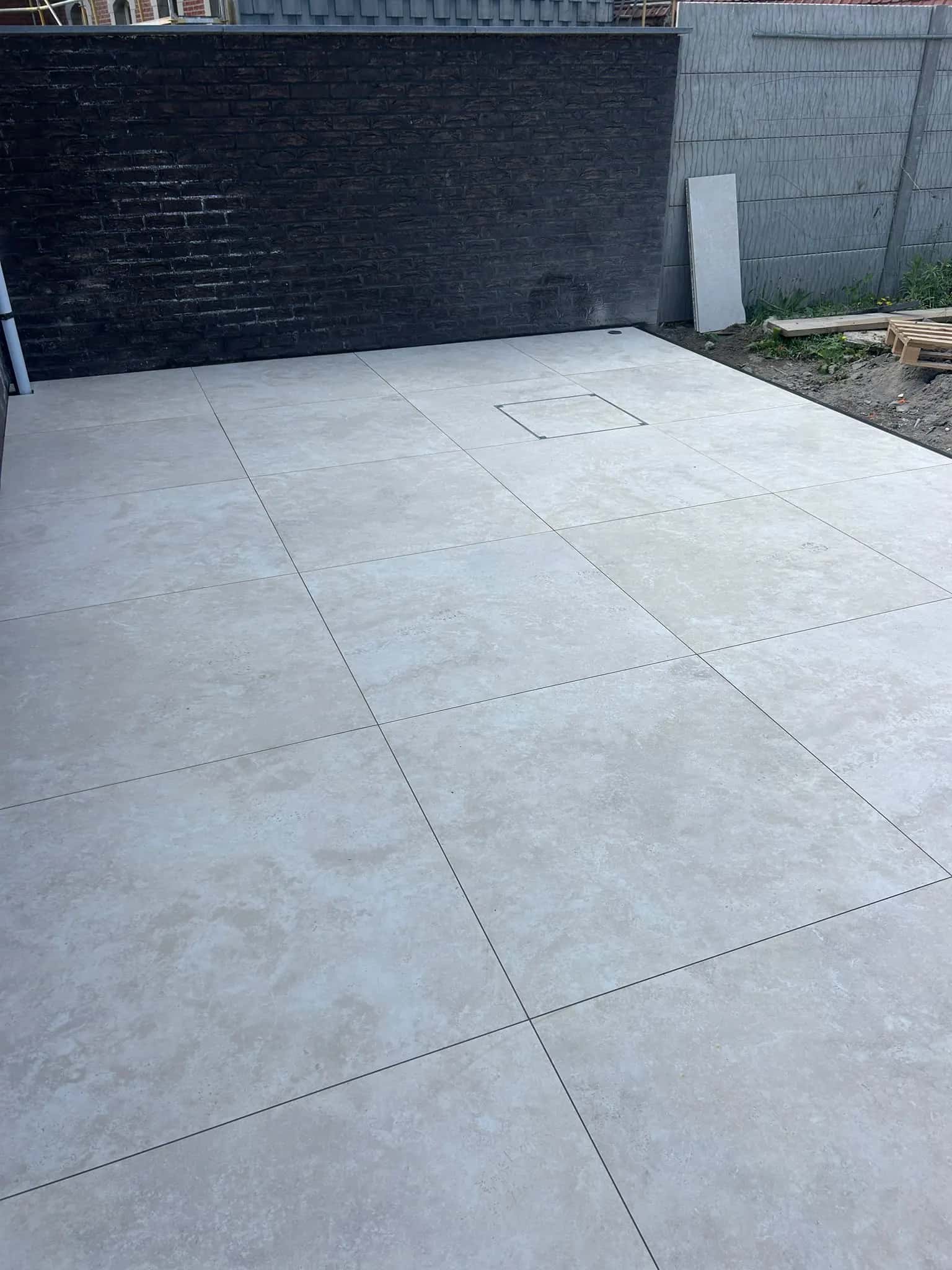 Trappe de visite carrelée dans la terrasse, le regard reste accessible