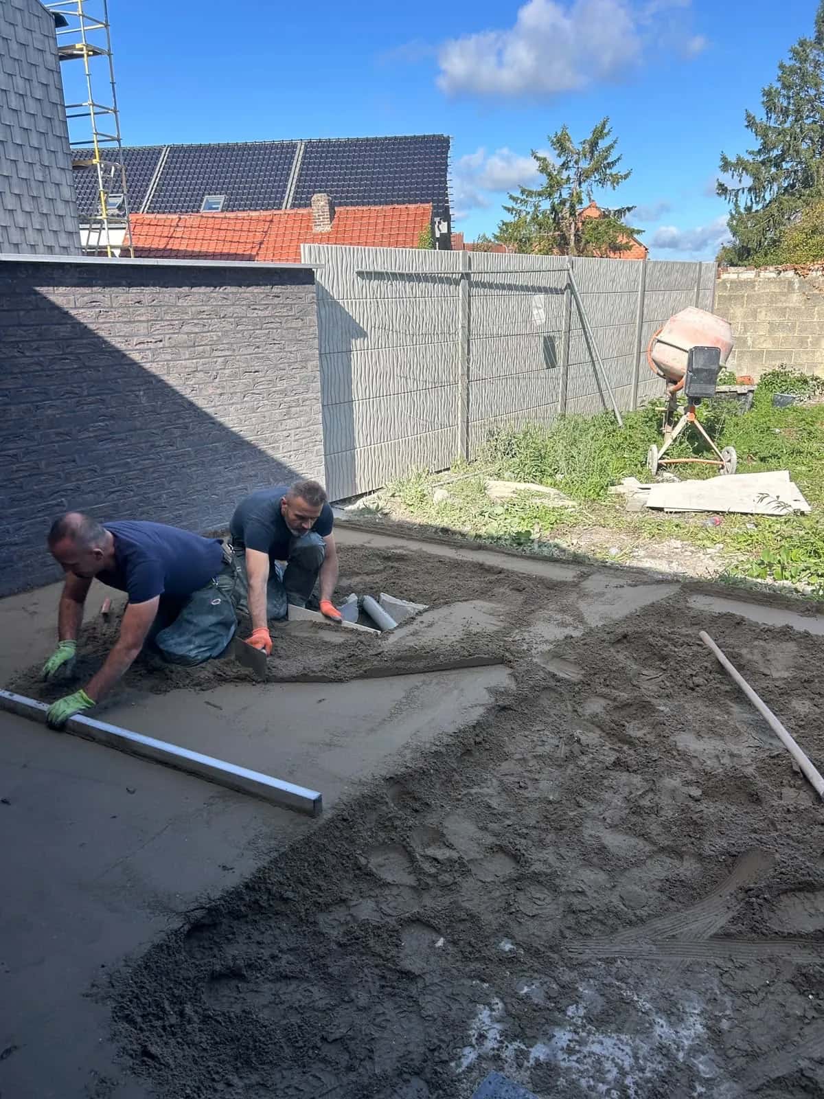 Les poseurs Km pose tirent la chape à la règle sur la terrasse