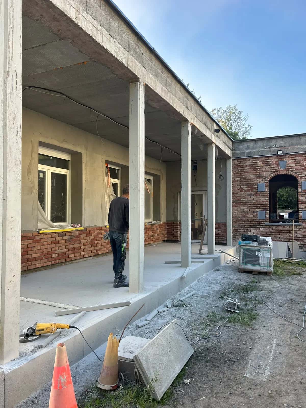 La galerie avant la pose : dalle béton brute et matériaux sur le côté