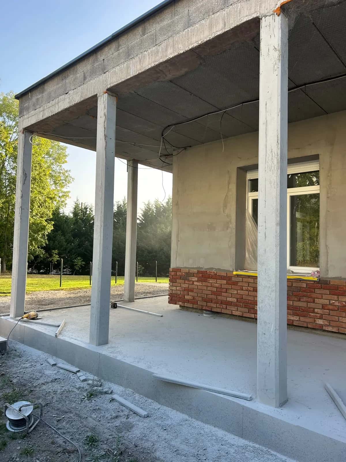 Dalle béton de la terrasse couverte entre les colonnes, avant la pose