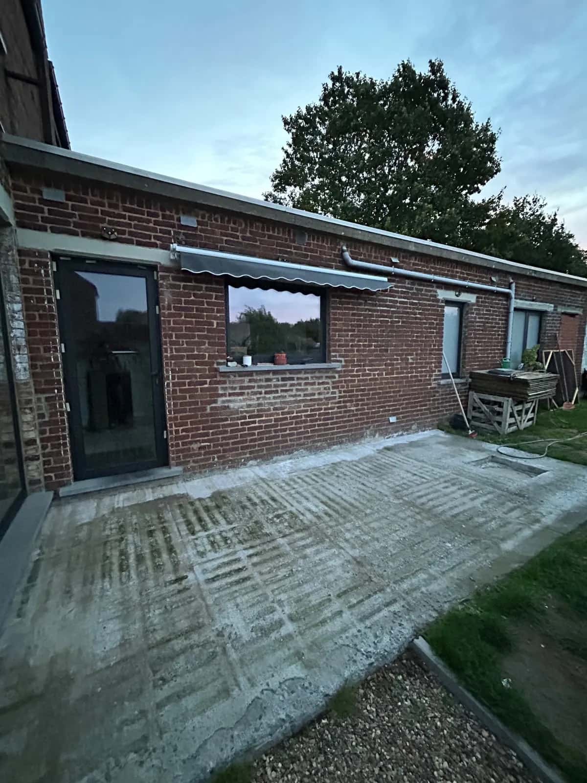 Dalle béton brute le long de l'aile de la maison, avant la pose des pavés