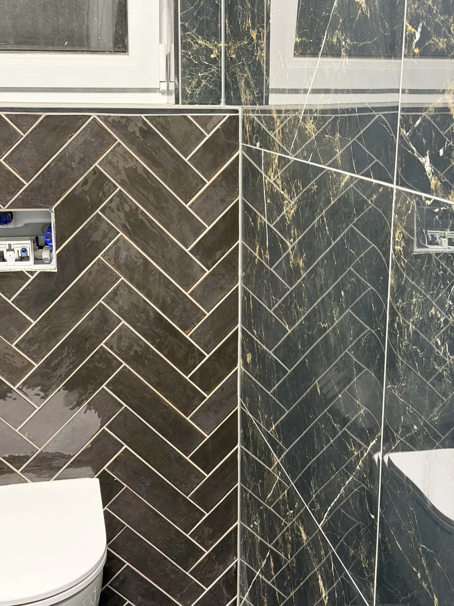 Détail du chevron mural contre le marbre noir, joints clairs réguliers